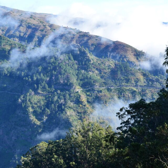A breathtaking mountain landscape with clouds covering the peaks.
