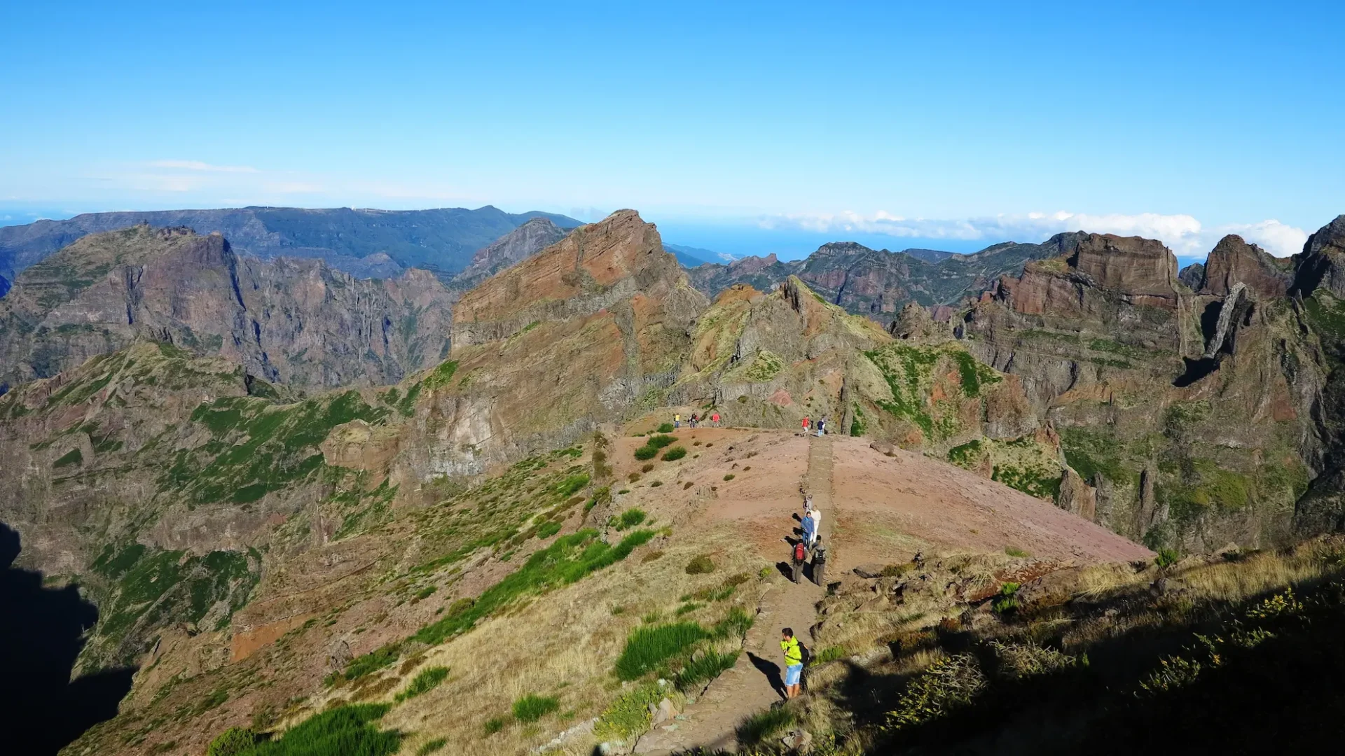 Pico do Arieiro Mountain Trail in Madeira – A scenic hiking path in Madeira, possibly part of the famous Pico do Arieiro to Pico Ruivo trek. The image showcases rugged peaks, clear skies, and hikers exploring the breathtaking mountain landscape.