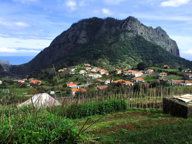 Traditional Madeira village with mountain views, seen from a scenic levada hiking trail.