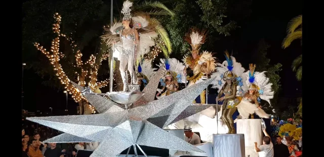 Carnival performers wearing vibrant costumes and masks during the Funchal Carnival Parade