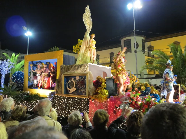 Traditional allegorical float decorated with flowers and lights during the Funchal Carnival Parade